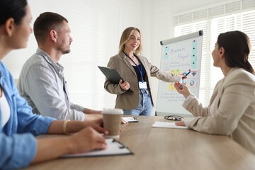 Woman giving public speech in front of audience indoors