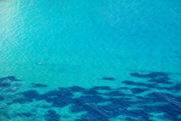 woman swiming in blue water in Roses, Spain