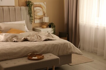 Comfortable bed with soft linens in stylish room. Interior design