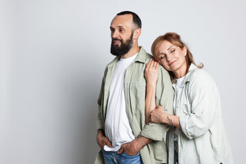 Portrait of lovely couple on light grey background, space for text