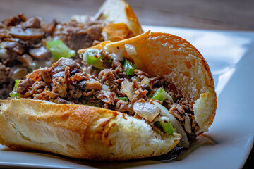 steak and cheese Philly sandwich served with lettuce and jalapeños.