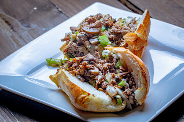 steak and cheese Philly sandwich served with lettuce and jalapeños.