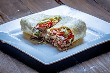 Mexican style tortilla wrap with beef and tomatoes and lettuce.