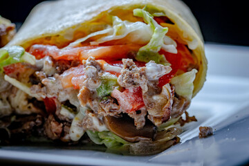 Mexican style tortilla wrap with beef and tomatoes and lettuce.