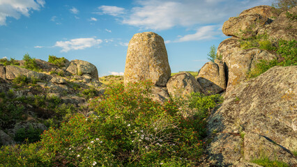 view to huge vertical granite boulder  in canyon under sky with clouds with copy space