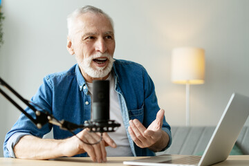 Senior man recording podcast using laptop and microphone