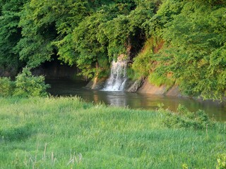 A stream flowing into a river in a mountain village at dusk, Oshu, Iwate, Japan