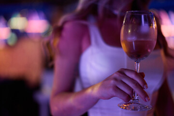 Elegant Woman Holding Wine Glass at Nightclub
