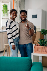 Fototapeta premium Happy couple showing keys of new home after moving in