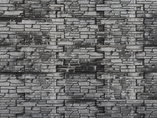 Obraz premium Black and grey textured tiles repeating the texture in blocks on a plaster wall