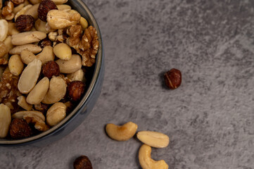 mixed nuts in a bowl,Dry fruits and nuts in bowl with concrete background, mix nuts in a bowl over dark background. Selective focus.