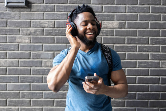 Filled with joy, a man dances and enjoys music through his headphones, capturing the essence of happiness in a lively atmosphere.