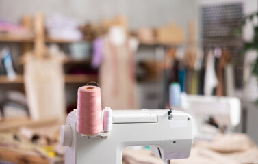 Sewing machine in dressmaker studios work area, close-up. Production of clothes according to...