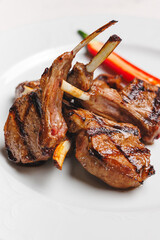 Grilled lamb chops with red chili on a white plate