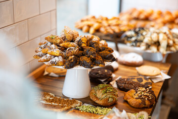 Fresh pastries, buns, croissants on the counter of the coffee shop. Sweet desserts and buns to order with coffee in a cafe