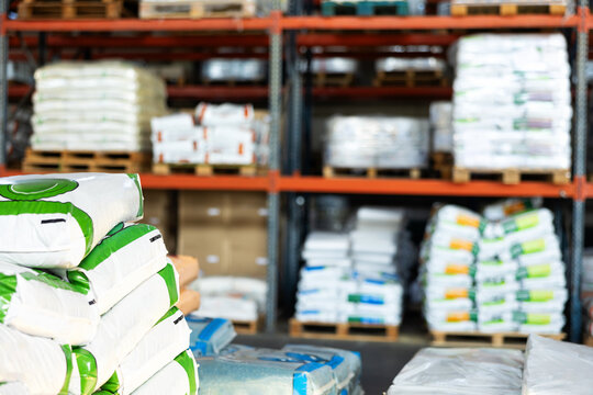 Several paper bags, bales, lie on trolley cart in the warehouse of wholesale store of building materials, gardening goods, fertilizers