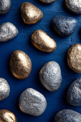 Close Up of Gold and Silver Pebbles on Dark Blue Surface