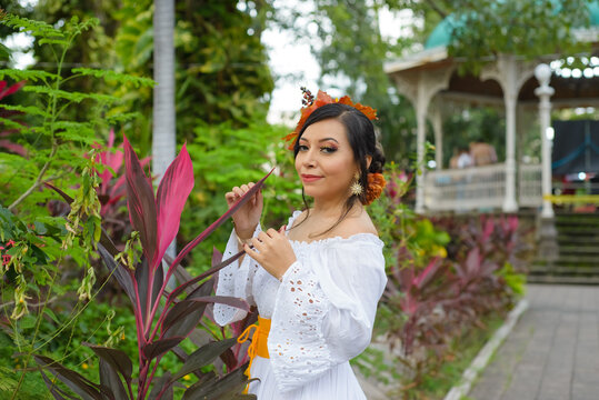 A woman in a white eyelet off-shoulder dress, adorned with a fall-themed leaf headpiece