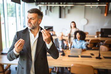 cheerful businessman left voice mail on mobile phone in the office