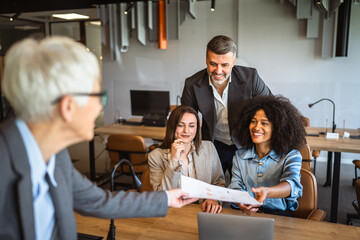 Confident senior businesswoman share documents with colleagues