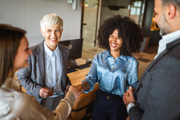 multicultural female colleagues handshaking on the meeting in office