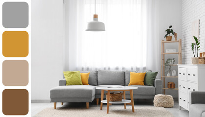 Interior of living room with grey sofa and table near window. Different color patterns
