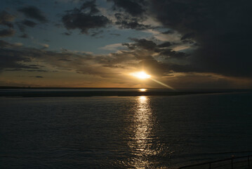 Sunset over the tranquil ocean reflecting warm colors at the horizon during twilight