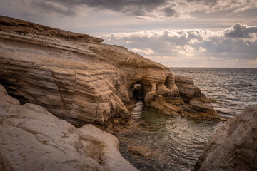 Sea caves, cliffs and arches landscape in Cyprus. White stones cave cliff rocks Mediterranean sea geologic panorama
