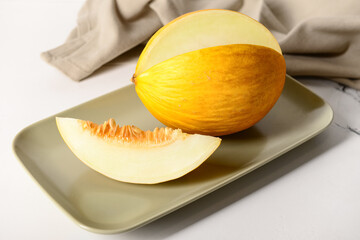 Plate with tasty ripe melon on table