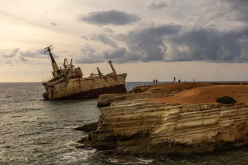Fototapeten Old rust ship wreck on a rocky coast  in Mediterranean sea at Akrotiri Beach in Cyprus. Shipwreck of the abandoned ship © Антонина Шатревич