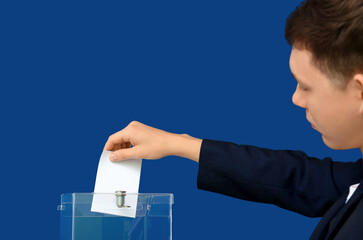 Voting young man near ballot box on blue background, back view