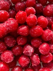 Top-down macro shot of a frozen cherry covered in ice crystals. Natural texture and frosty detail highlight the freshness and coldness. Concept of freezing, preservation, and raw fruit.