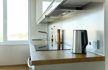 A bright kitchen set with a stylish bouquet in a stylish living room, on the surface there is a pepper shaker, a salt shaker and a kettle