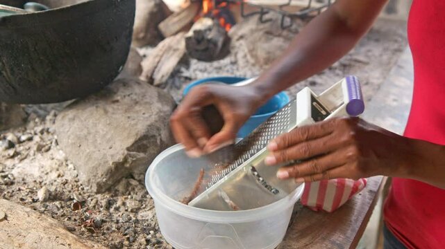 May 25, 2024: Hato Mayor, Dominican Republic, woman grating handmade chocolate into bowl for traditional hot chocolate preparation