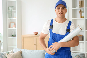 Obraz premium Male worker with roll of stretch wrap in room