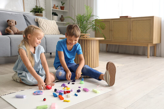 Little children sculpting from plasticine on floor at home - Powered by Adobe