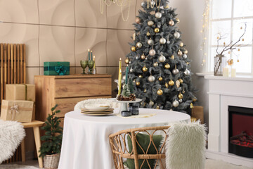 Interior of dining room with table, fireplace and Christmas tree