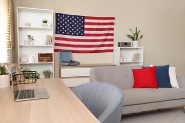 Interior of living room with USA flag, sofa and workplace