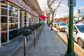 Rows of sidewalk cafes along Sherman Avenue with the lake in the distance in downtown Coeur d'Alene, Idaho.