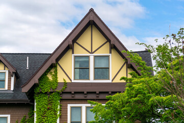 Elegant Tudor-style gabled facade with double windows and ivy wall in Brighton, Massachusetts, USA
