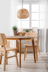 Interior of stylish living room with table, chairs and potted lavender flowers