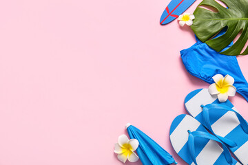 Summer composition with flip-flops, decorative surfboard and umbrella on pink background