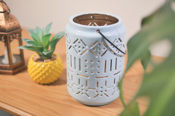 Decorative lantern and potted plant on wooden table