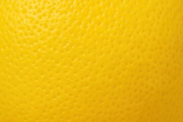 Yellow lemon peel macro showing bright color and detailed bumpy texture of citrus skin

