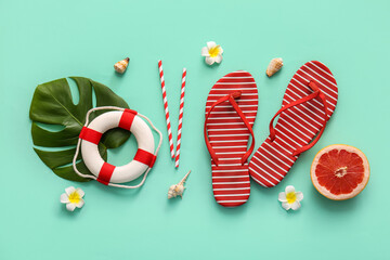 Summer composition with plumeria flowers, tropical leaf and flip-flops on turquoise background