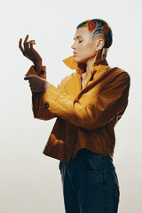 creative woman with colorful artistic hairstyle wearing mustard yellow jacket and denim jeans...