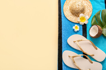 Beach towel, coconut, flip-flops and wicker hat on beige background, closeup