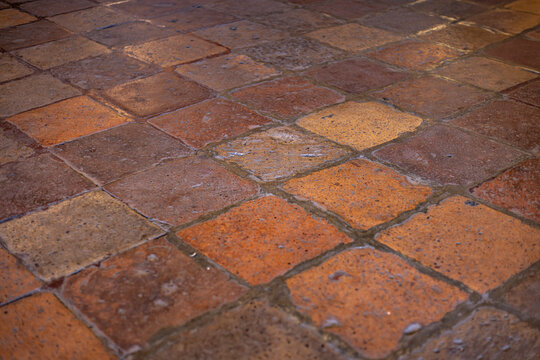 Piso cuadriculado colores terracota. Loseta de barro desgastada y vieja. Vintage color marron rojizo. Lechada gris obscuro.