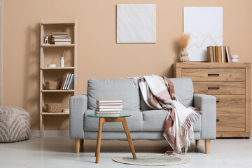 Stylish interior of stylish living room with books on table