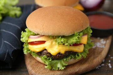Tasty cheeseburger with sauce on table, closeup
